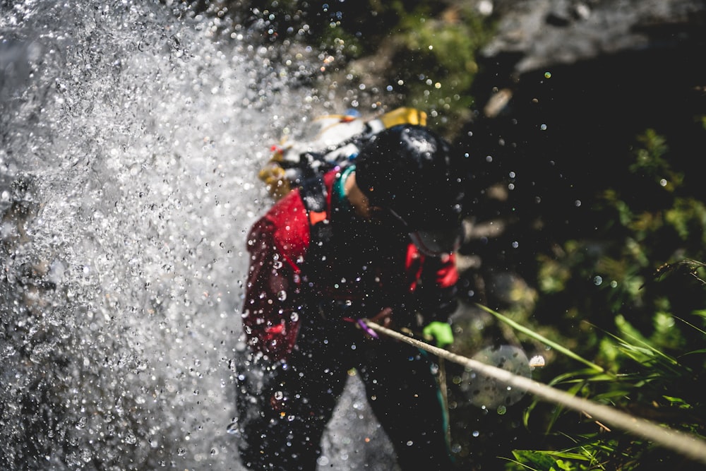 a man in a wet suit spraying water on himself