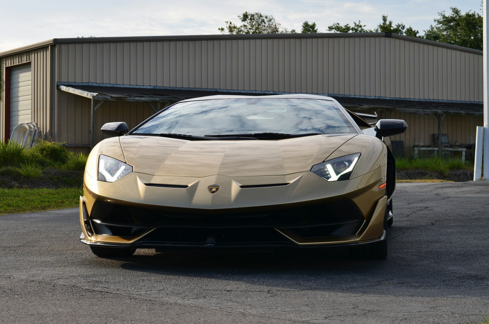 a gold colored sports car parked in front of a building