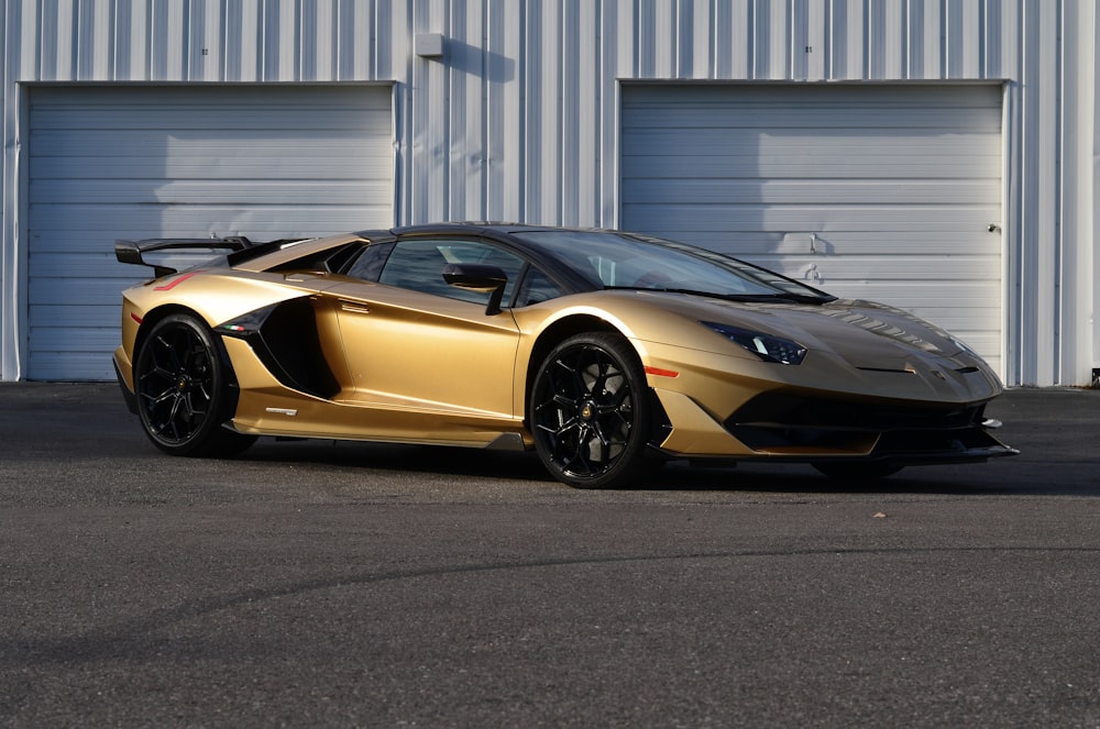 a gold colored sports car parked in front of a building