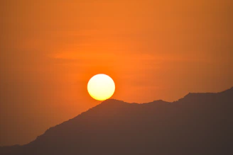 A vibrant sunset over a mountain ridge, capturing the golden hour's warm glow.