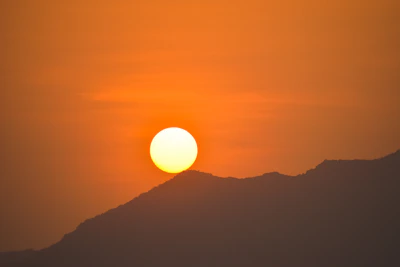 A vibrant sunset over a mountain ridge, capturing the golden hour's warm glow.