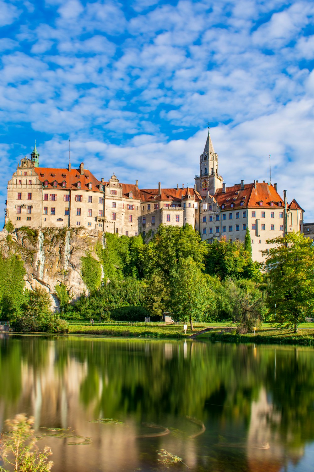 um castelo com um lago em frente a ele