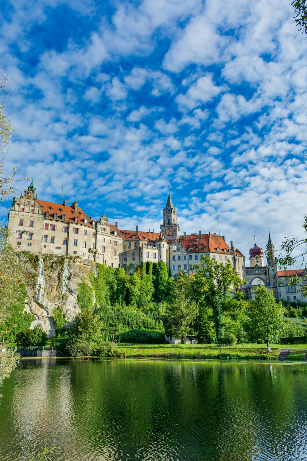 um grande castelo sentado no topo de uma encosta verde exuberante