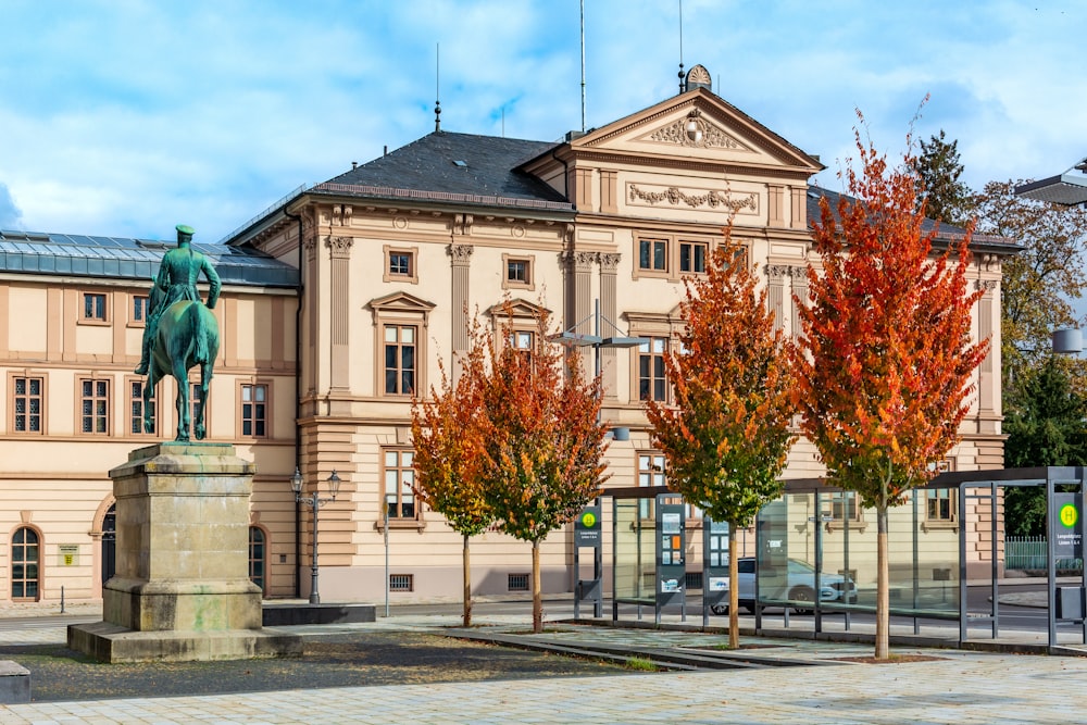 a statue of a man riding a horse in front of a building