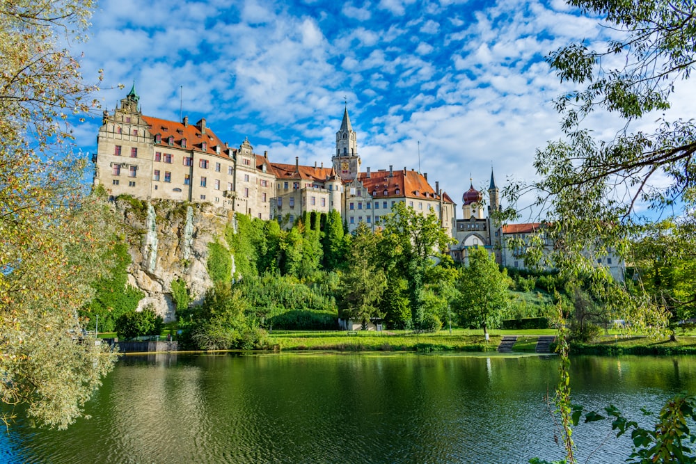 a large castle sitting on top of a lush green hillside