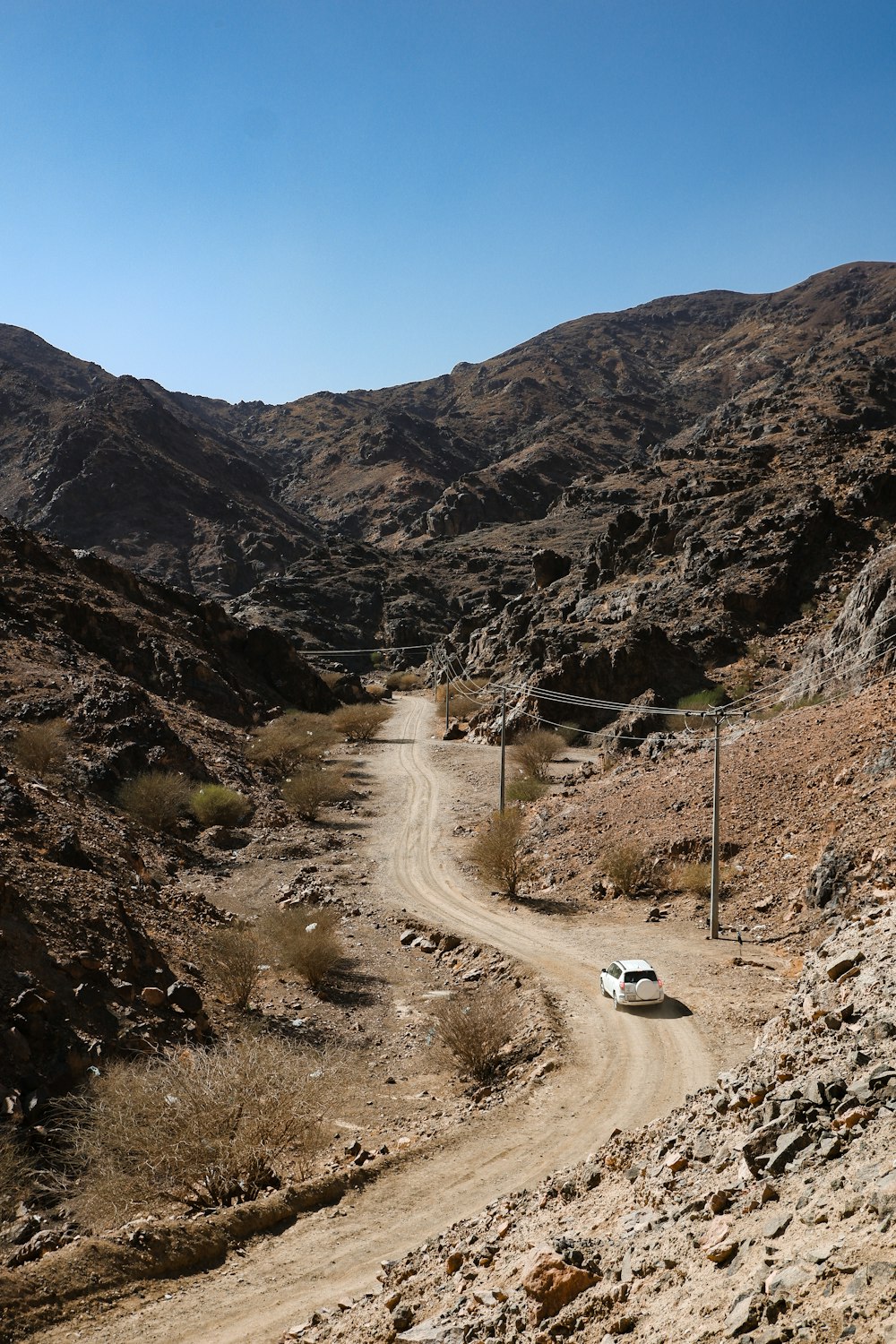 a car driving down a dirt road in the mountains