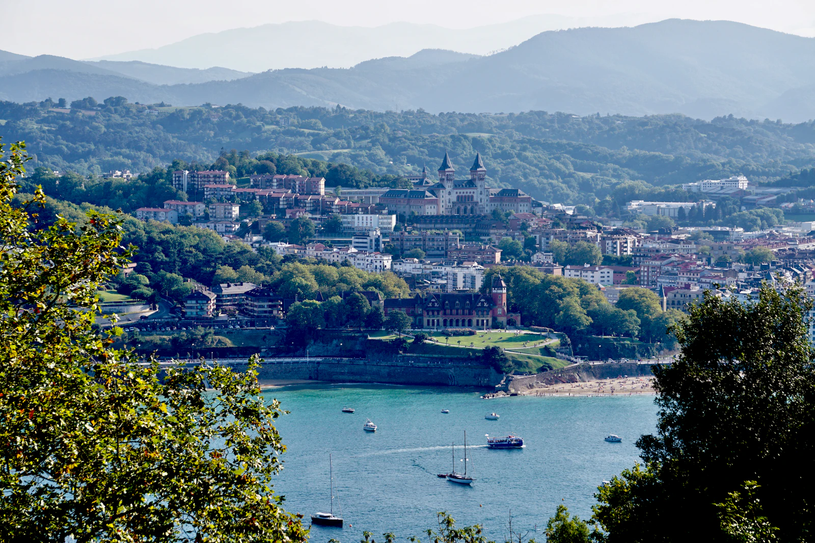 a view of a city and a lake with boats in the water