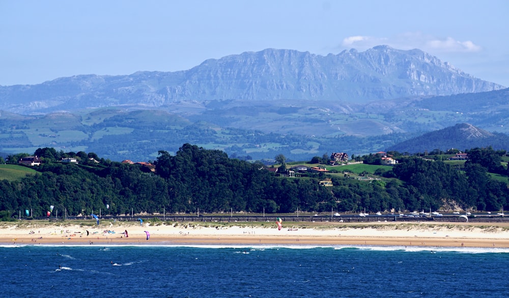 une vue d’une plage avec des montagnes en arrière-plan