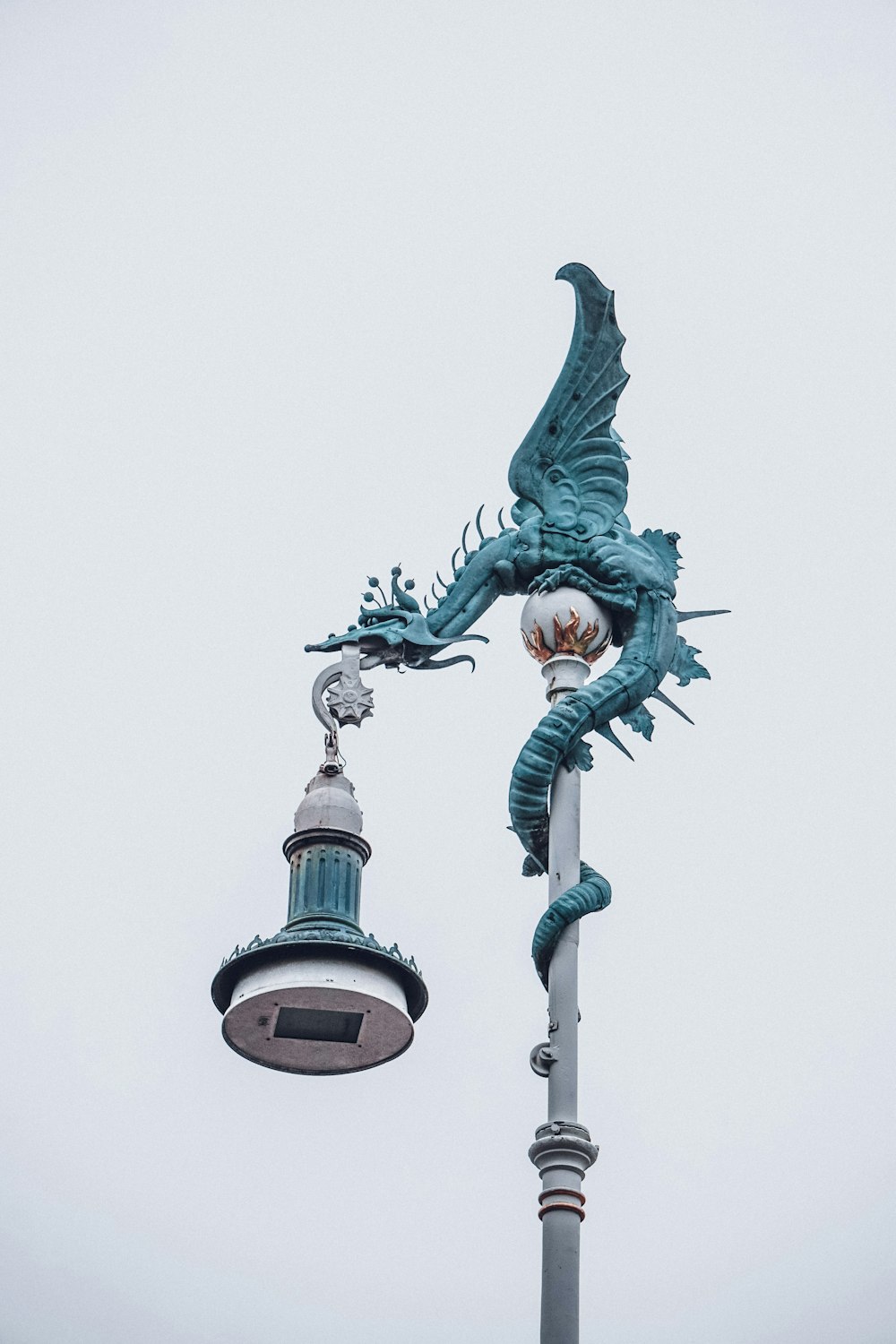 a dragon statue on top of a street light