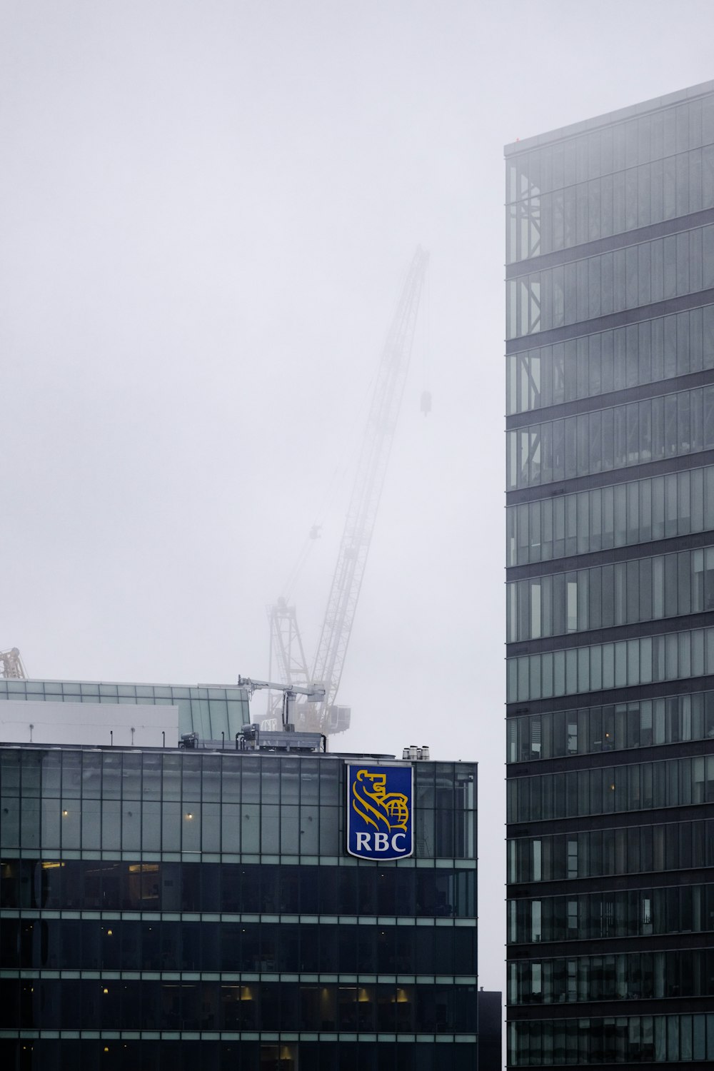 a tall building with a crane in the background