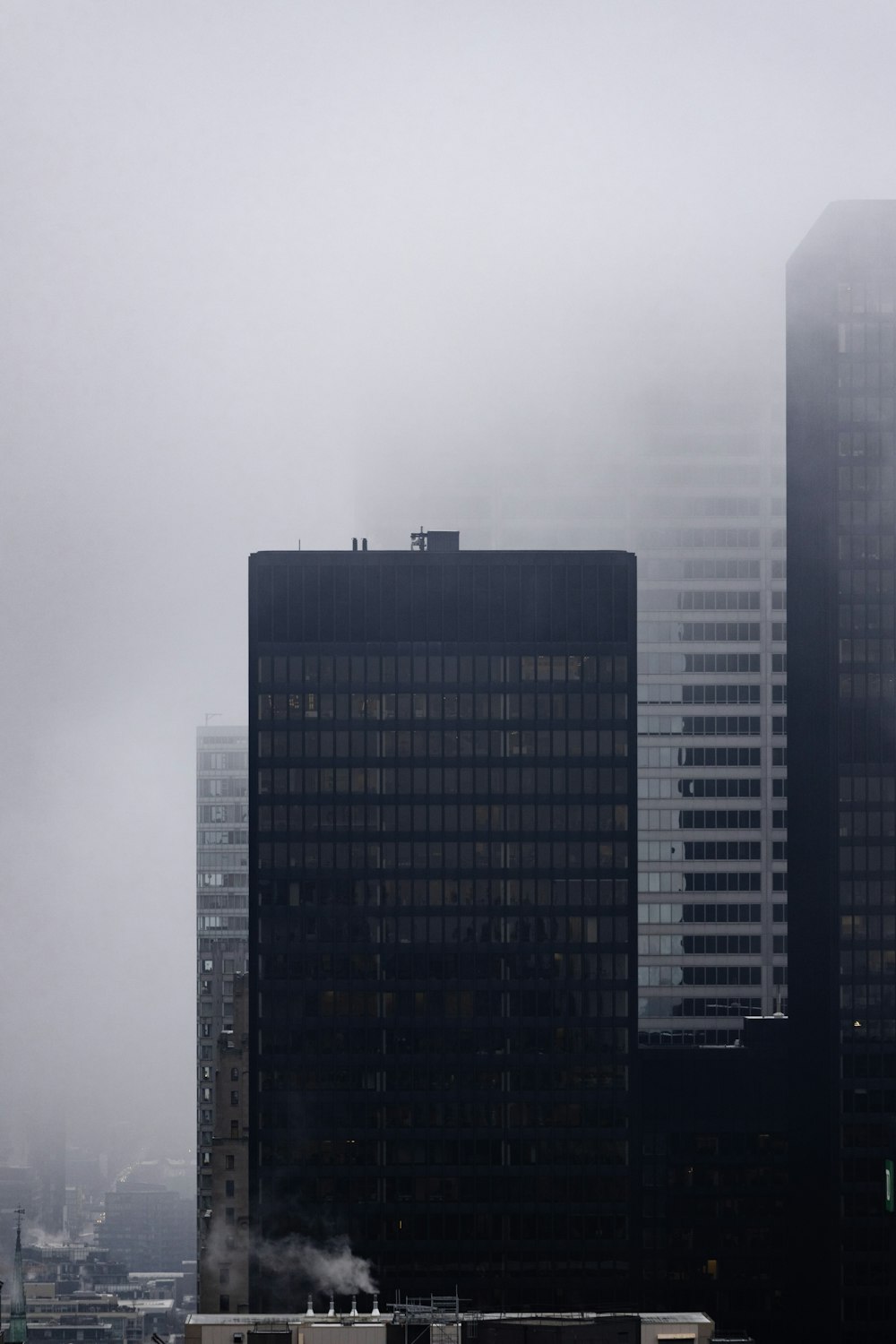 a view of a city with tall buildings on a foggy day
