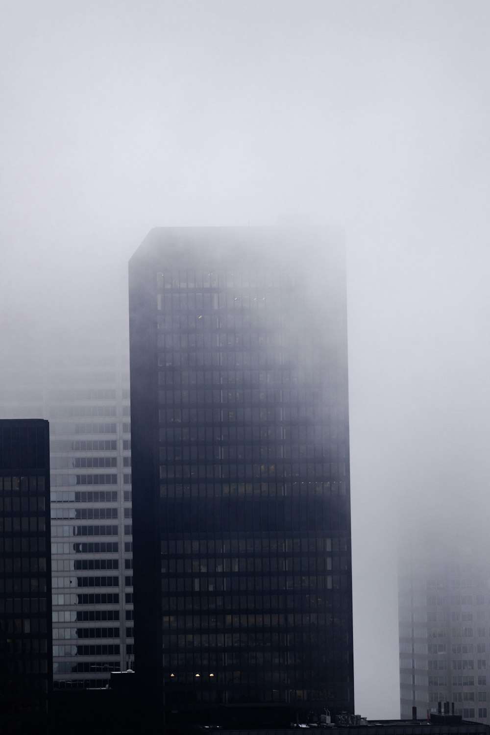 a very tall building in the middle of a foggy city