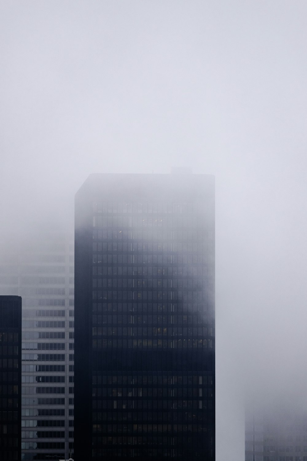 a very tall building in the middle of a foggy city