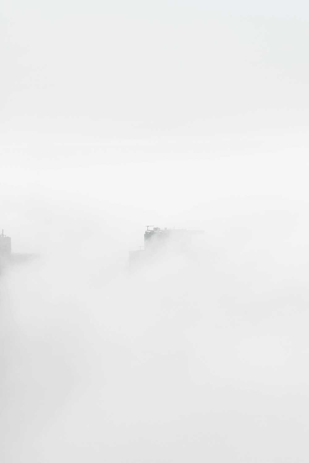 a foggy sky with a couple of boats in the water