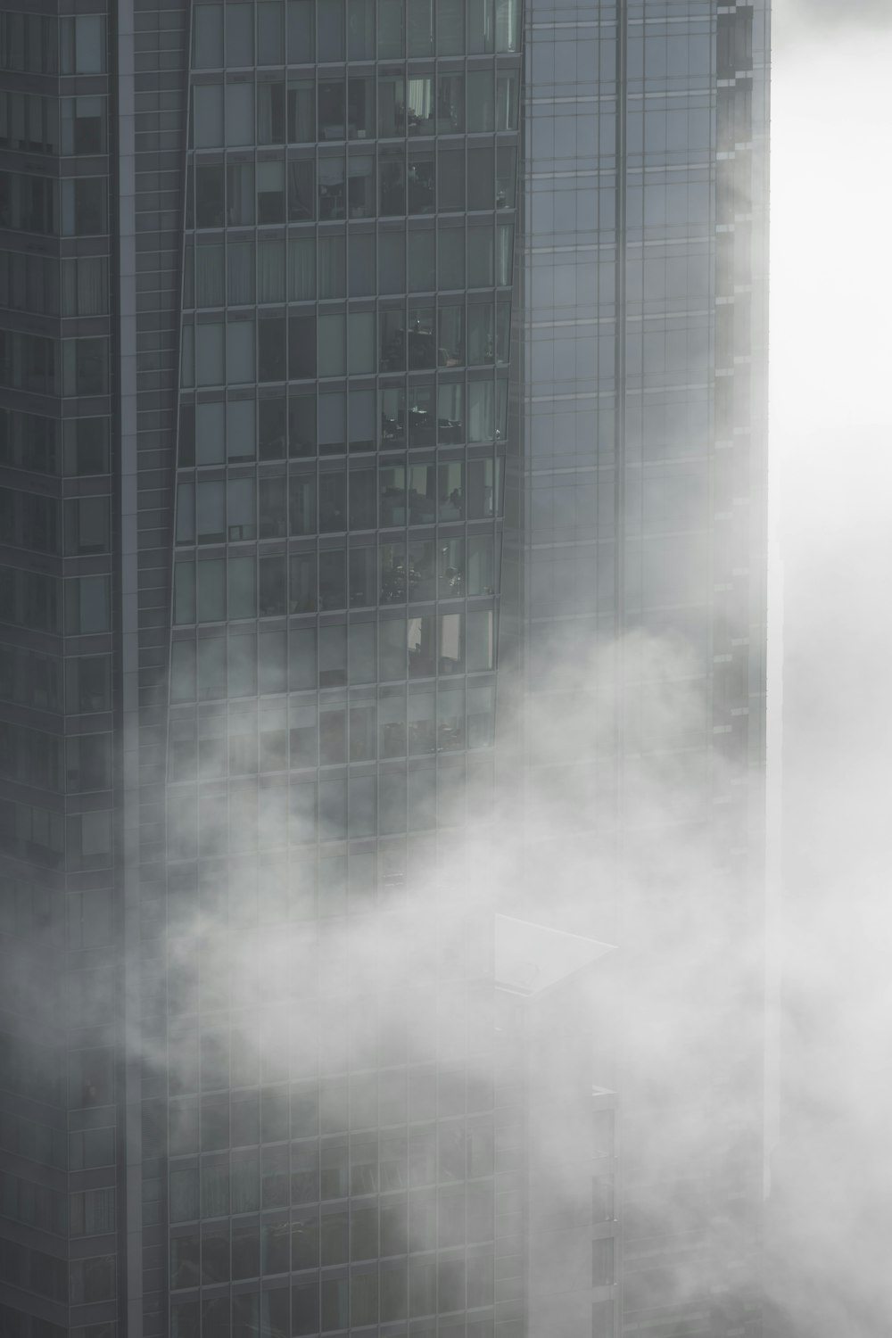 a very tall building with a lot of clouds in front of it