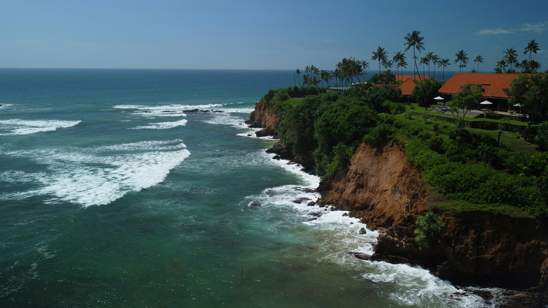 a cliff overlooking the ocean with houses on it