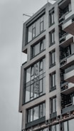 Sleek commercial building with large glass windows and grey exterior in an urban setting