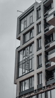 Exterior view of a modern commercial building with charcoal accents and expansive glass panels.