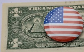 a button with the american flag on top of a one dollar bill