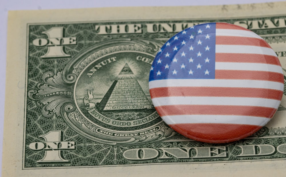 a button with the american flag on top of a one dollar bill