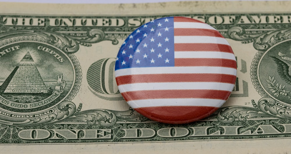 a button with the american flag on top of a one dollar bill