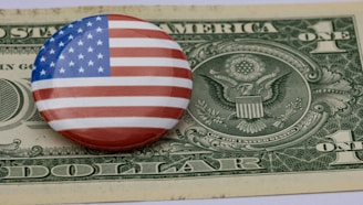 a button with the american flag on top of a one dollar bill