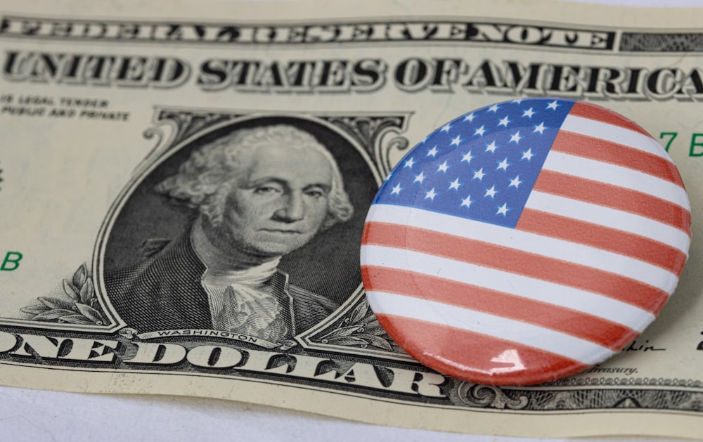Un billete de un dólar y un botón con una foto de George Washington