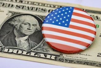 a button with the american flag on it sitting on top of a hundred dollar bill
