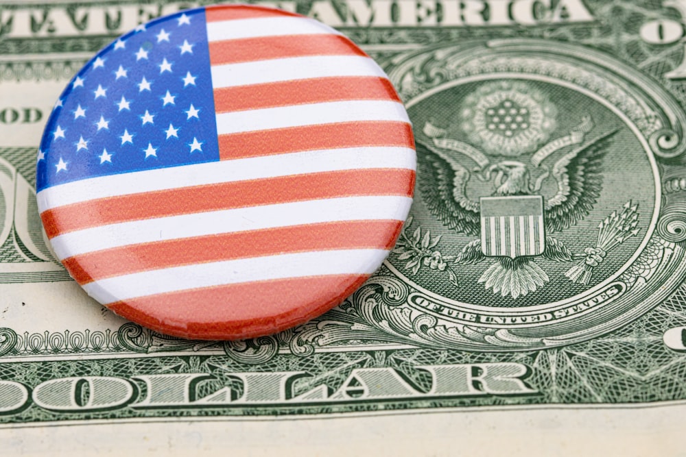 a button with the american flag on top of a dollar bill