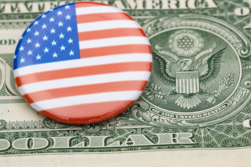 a button with the american flag on top of a dollar bill