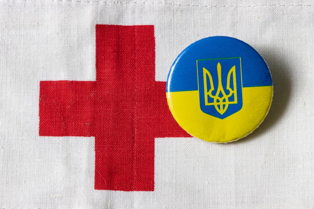 Un pulsante con la bandiera dell'Ucraina e una croce rossa