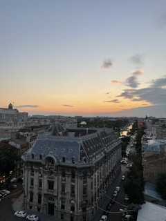 A panoramic view of Bhubaneswar city skyline with a luxury car parked nearby at dusk.