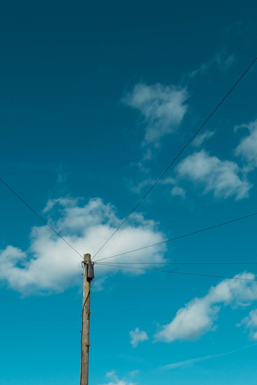 Poste y cables de teléfono contra un cielo azul