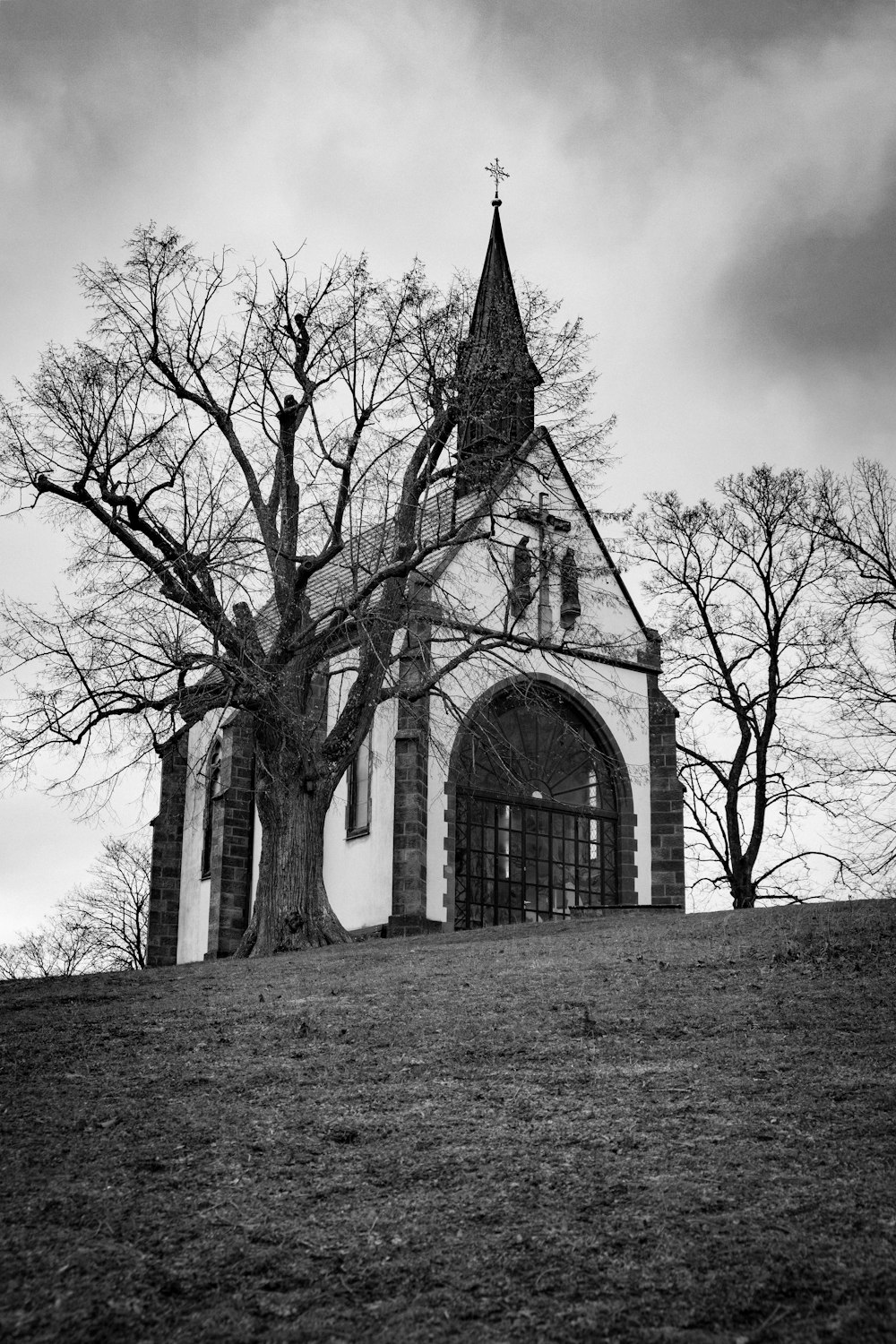 uma foto em preto e branco de uma igreja em uma colina