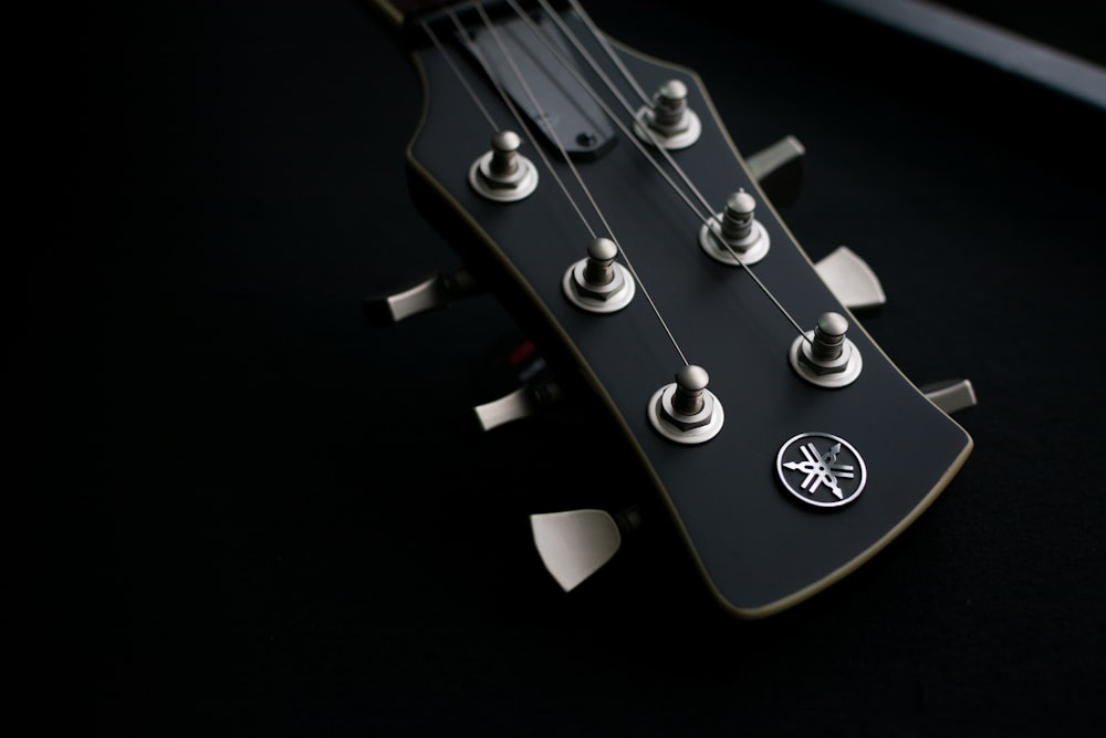 a close up of a guitar neck with a black background