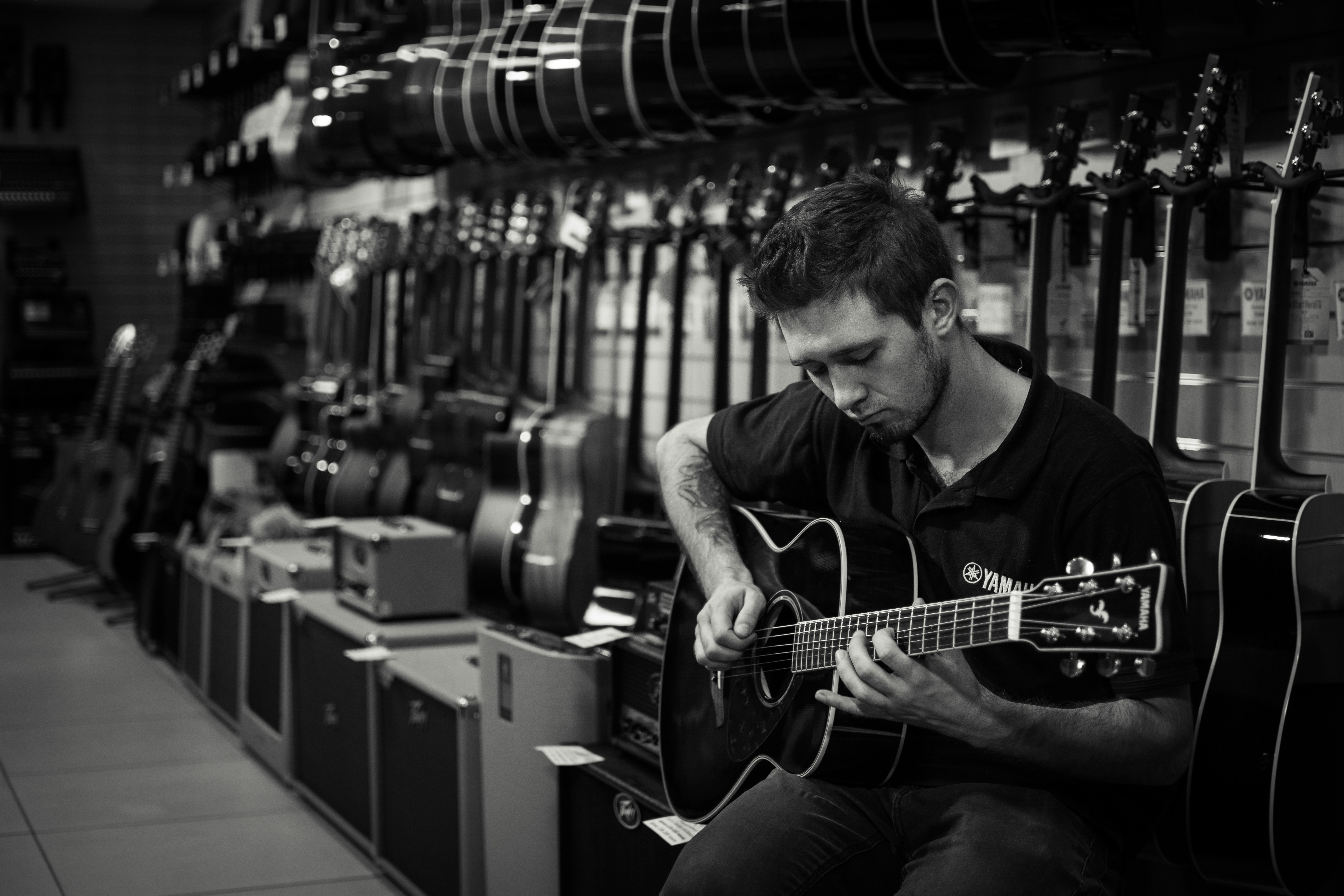 a man playing a guitar in a music store