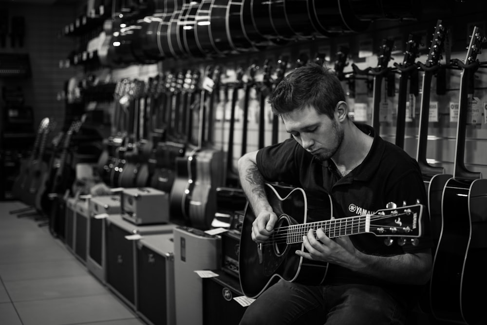 a man playing a guitar in a music store