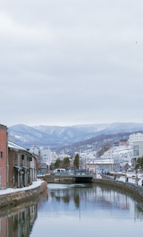 a body of water surrounded by buildings and mountains