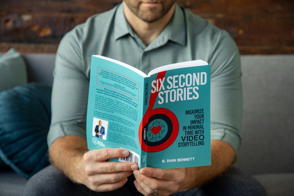 a man sitting on a couch holding a book