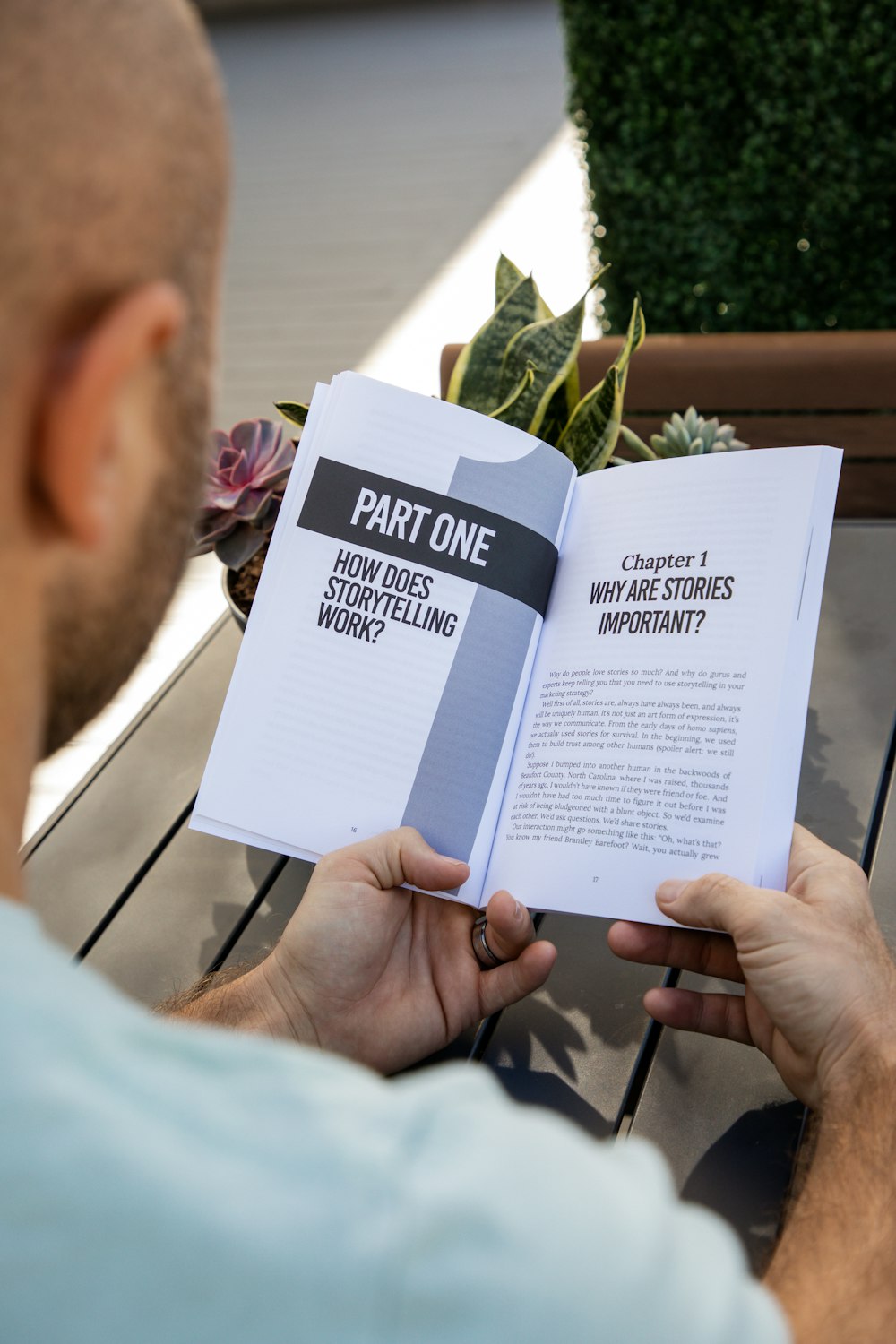 a man sitting on a bench reading a book