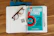 A wooden desk holds an open lined notebook with tortoiseshell eyeglasses and a QR code card resting on the pages. Adjacent to the notebook is a blue book titled 'Six Second Stories,' which focuses on maximizing impact with video storytelling. A silver pen is placed beside the notebook.