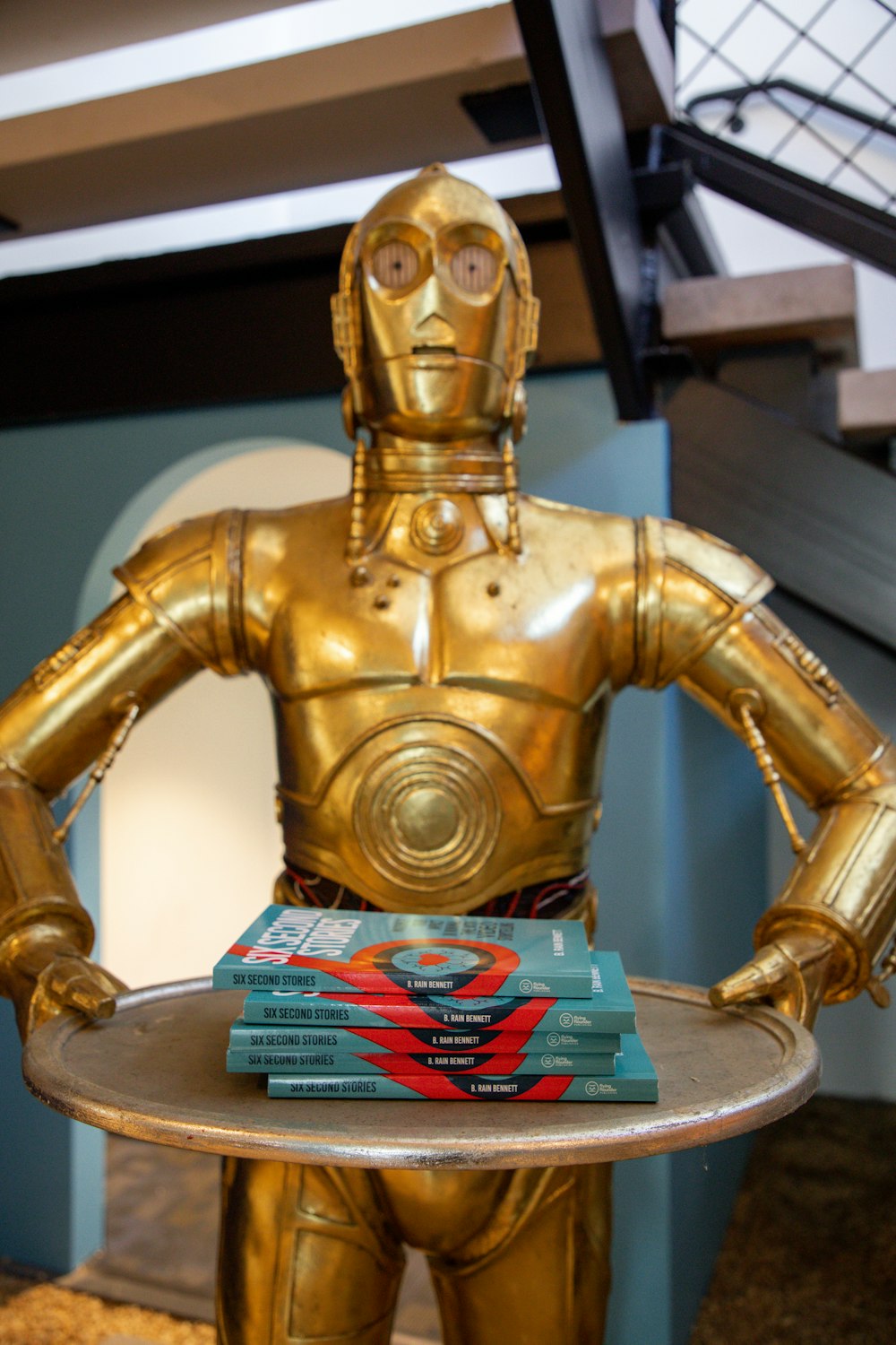 a star wars action figure holding a tray of books