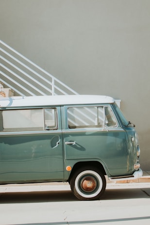 A pristine 1960s Volkswagen Transporter T1 parked in a sunlit vintage garage.
