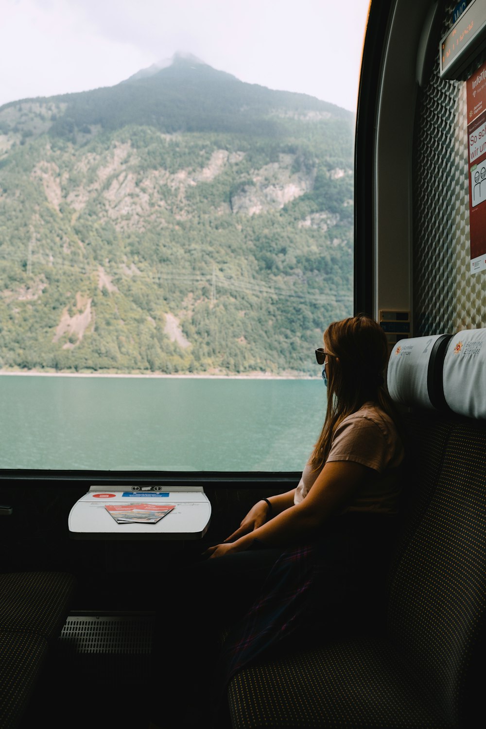 a woman sitting on a train looking out the window