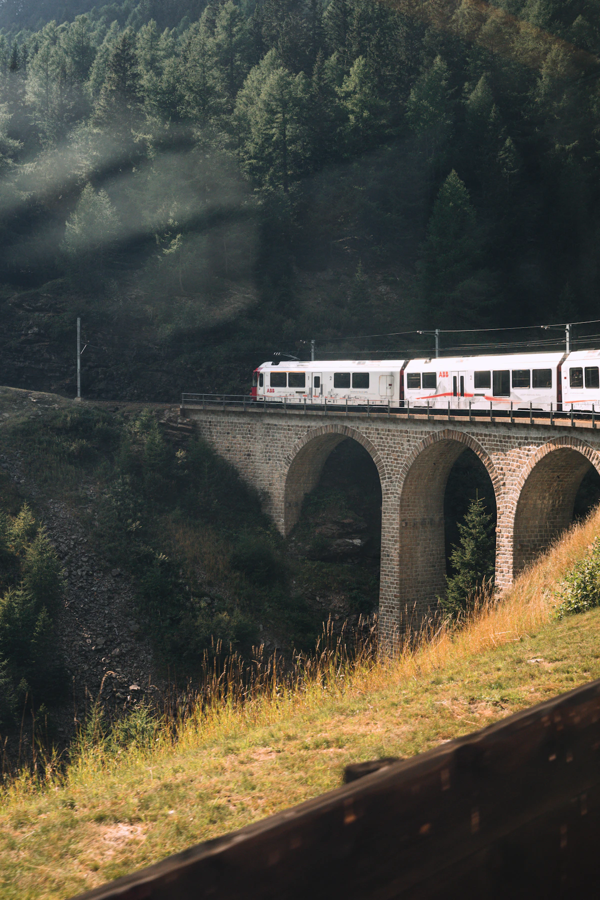 Glacier Express train crossing a mountain viaduct in the Swiss Alps
