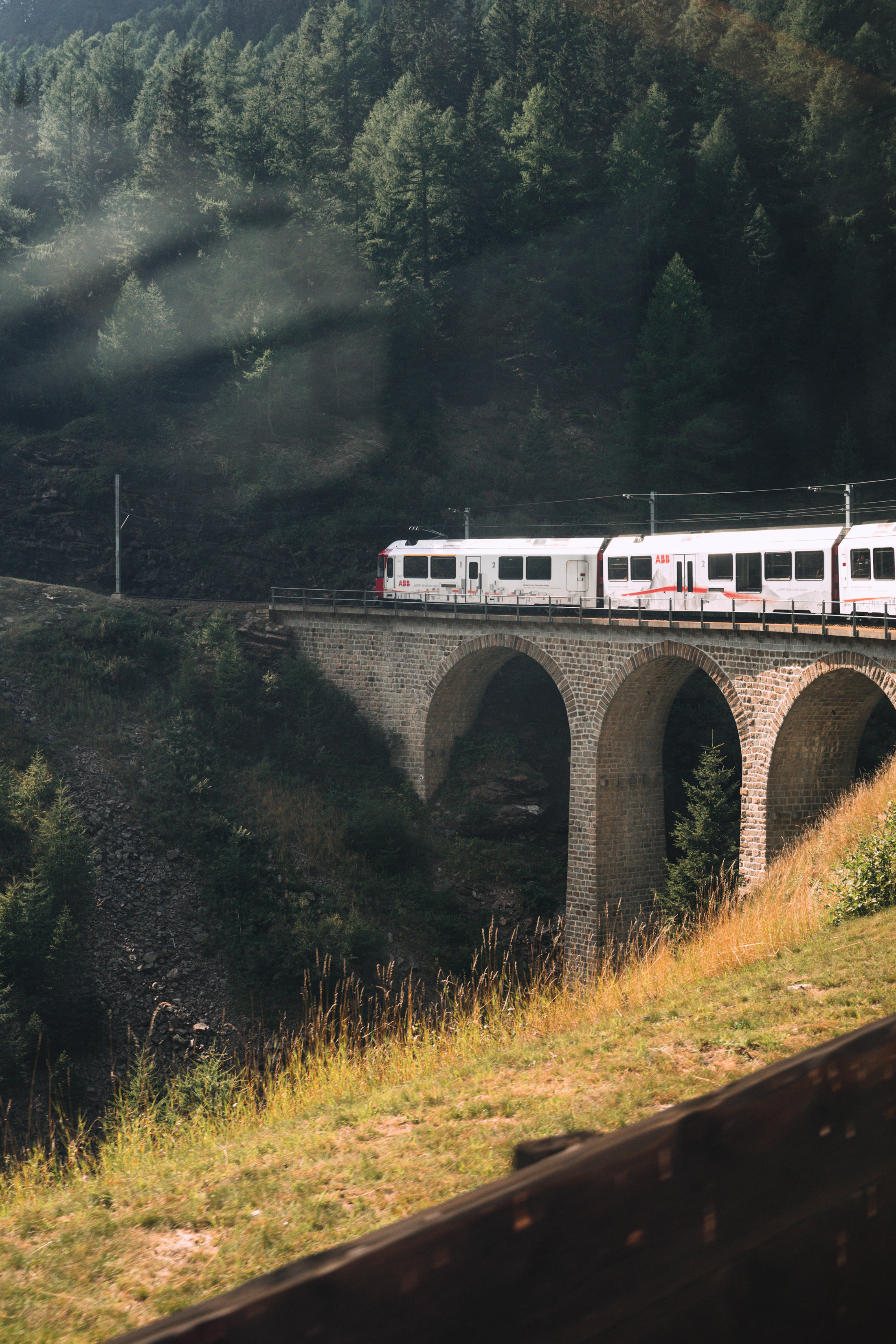 Glacier Express train crossing a mountain bridge in Switzerland