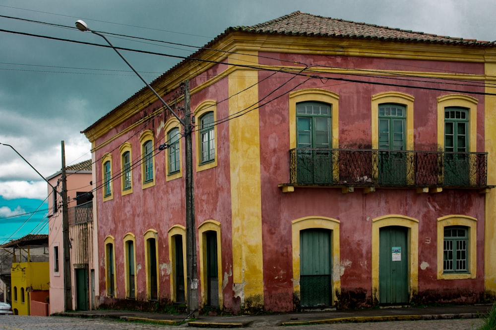 a red and yellow building with green shutters