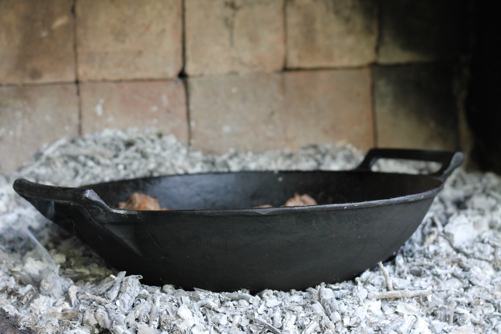 a black bowl sitting on top of a pile of wood