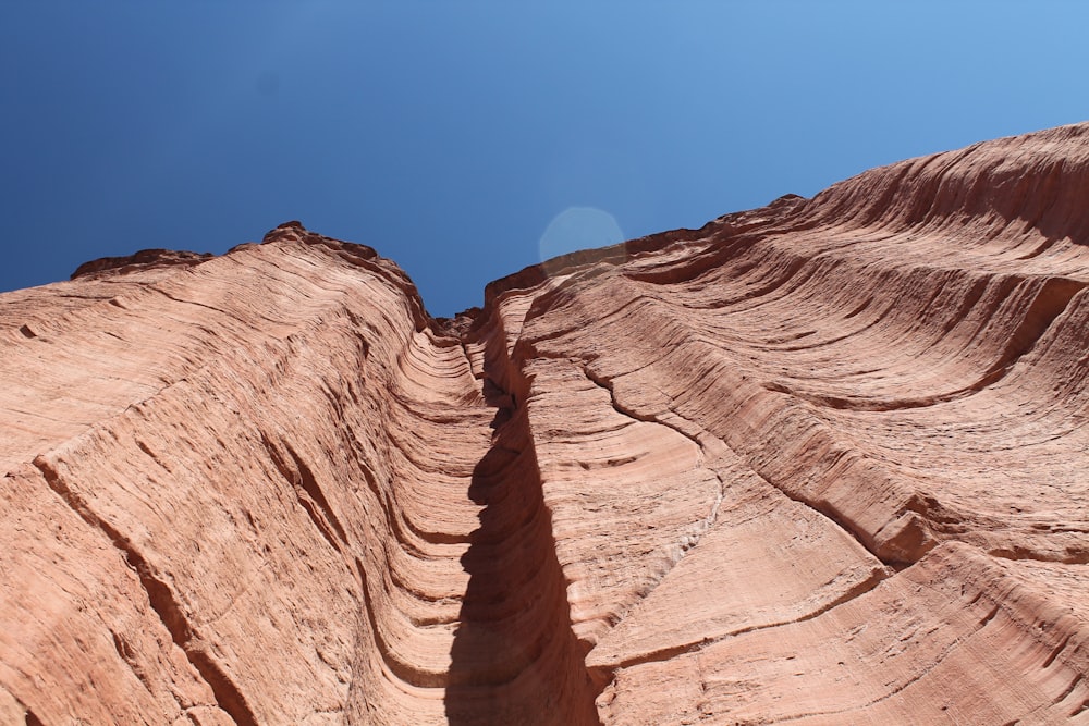 a very tall rock formation with a sky background