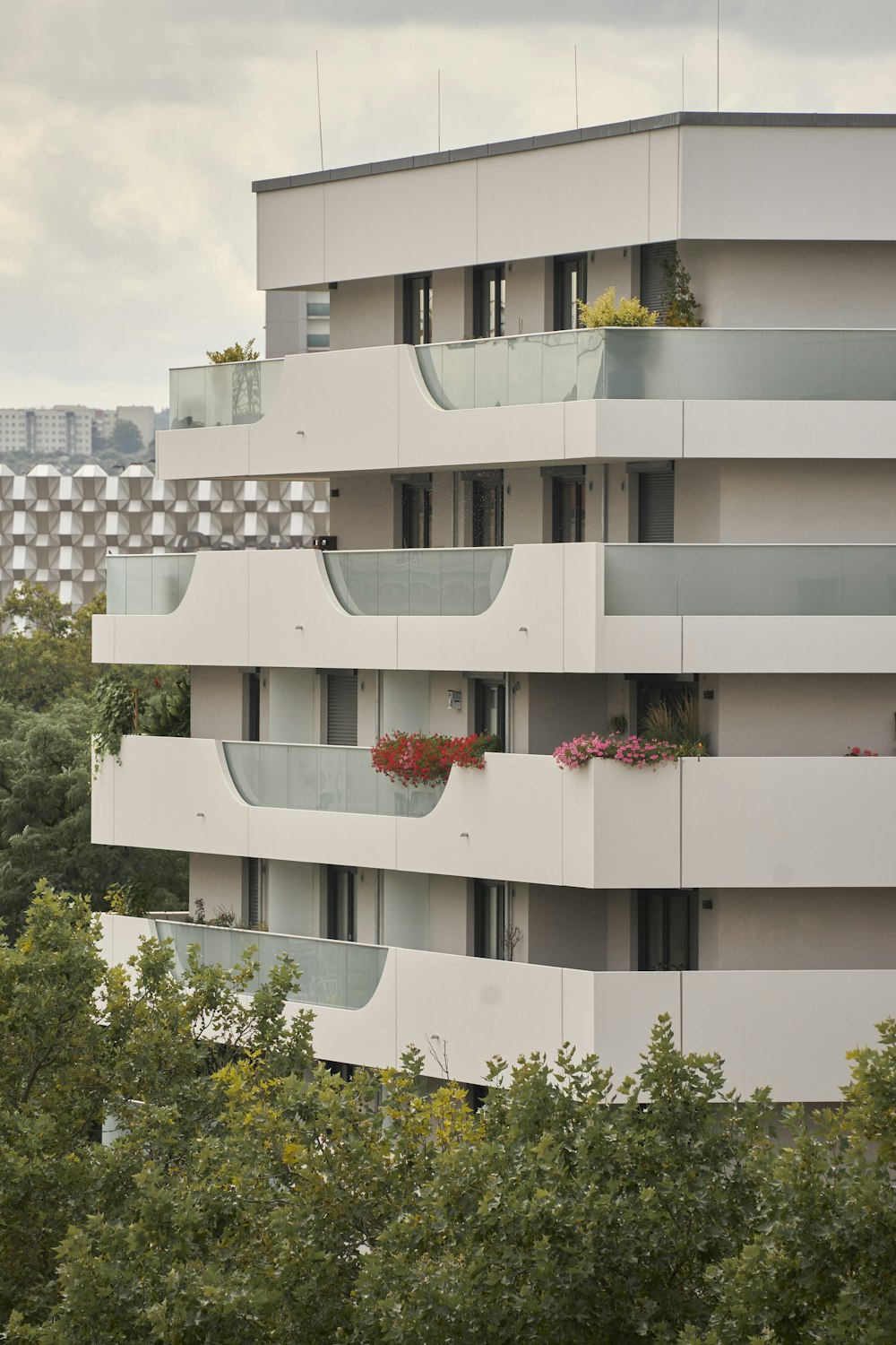 an apartment building with balconies and plants on the balconies